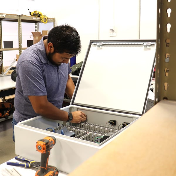 Cubiscan employee building a control box for integrated dimensioning, weighing, scanning, and sortation systems